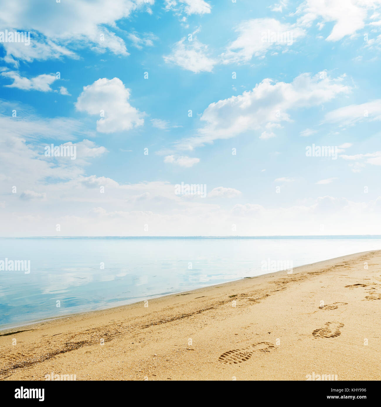 riverside with sand and clouds in blue sky Stock Photo - Alamy