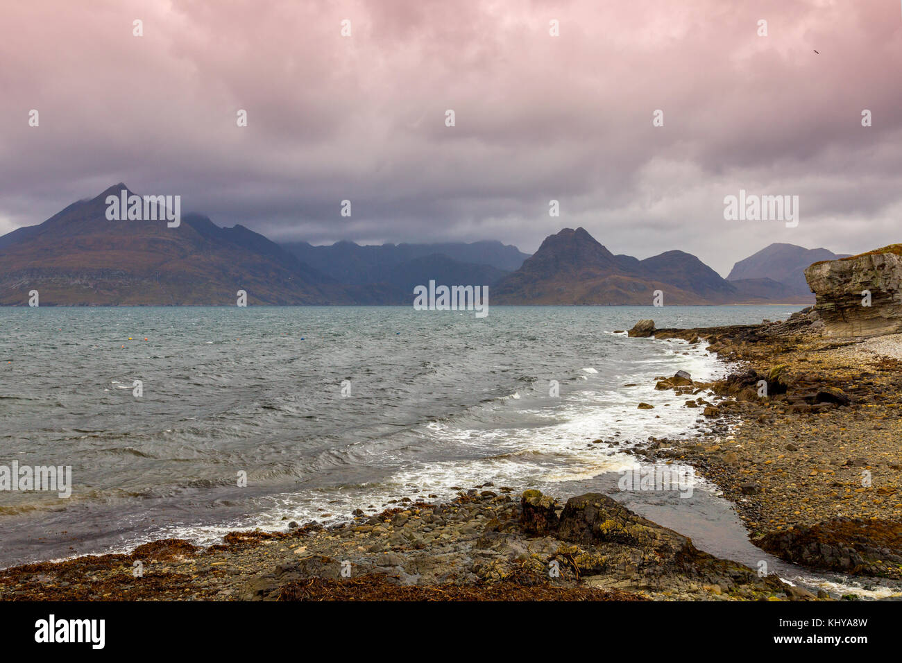 Brooding clouds and dark skies hang over the Black Cuillin hills viewed from Elgol beach on the Isle of Skye, Scotland, UK Stock Photo