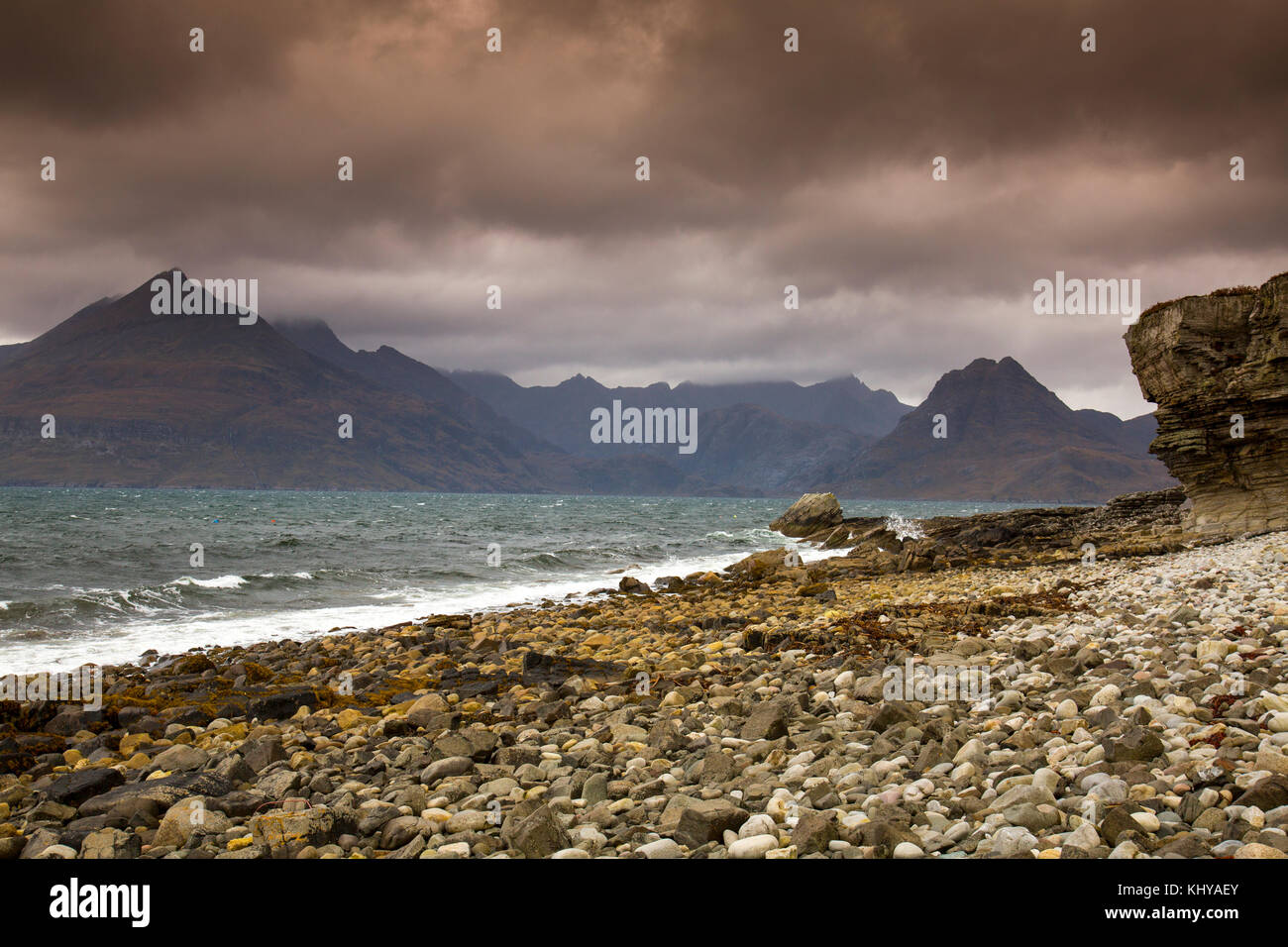 Brooding clouds and dark skies hang over the Black Cuillin hills viewed from Elgol beach on the Isle of Skye, Scotland, UK Stock Photo