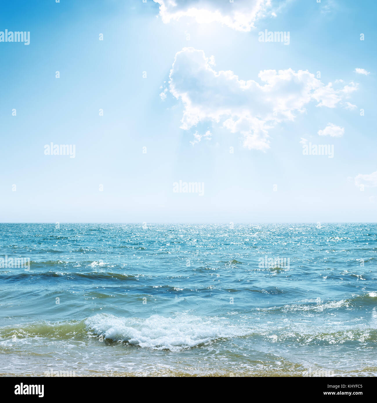 blue sky with clouds and sun over sea and reflections Stock Photo - Alamy