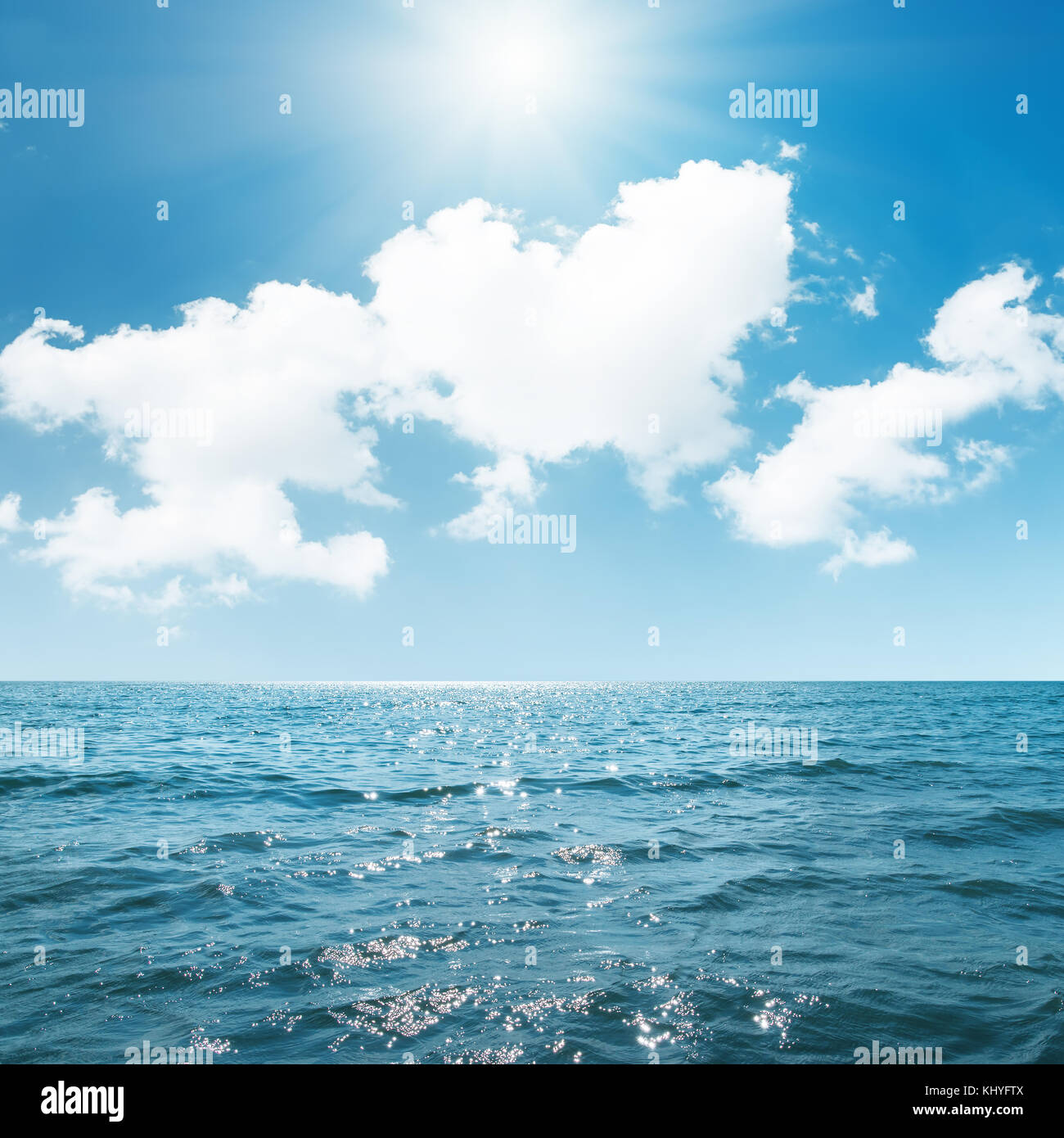 sun in blue sky over clouds and sea Stock Photo - Alamy