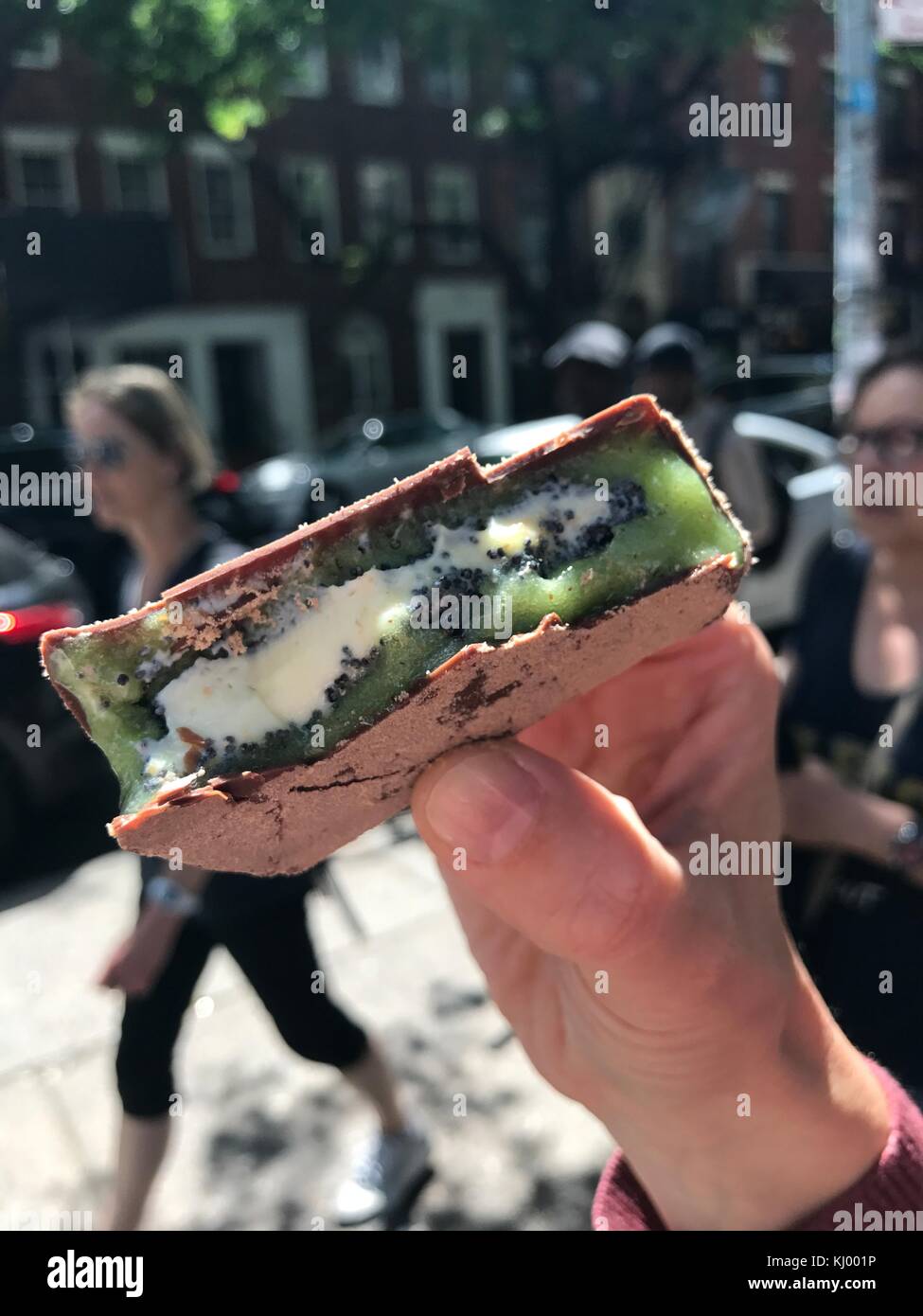 New York, USA. 03rd June, 2017. A person presents a kiwi ice cream sandwich with a vanilla ice cream core surrounded by kiwi sorbet and coated with chocolate in New York, US, 03 June 2017. · NO WIRE SERVICE · Credit: Christina Horsten/dpa/Alamy Live News Stock Photo