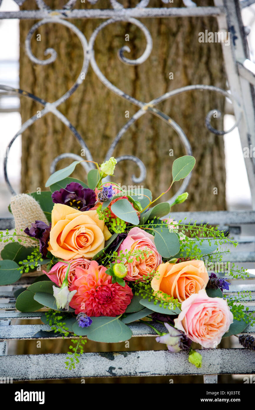Colourful bridal bouquet on rustic garden bench Stock Photo
