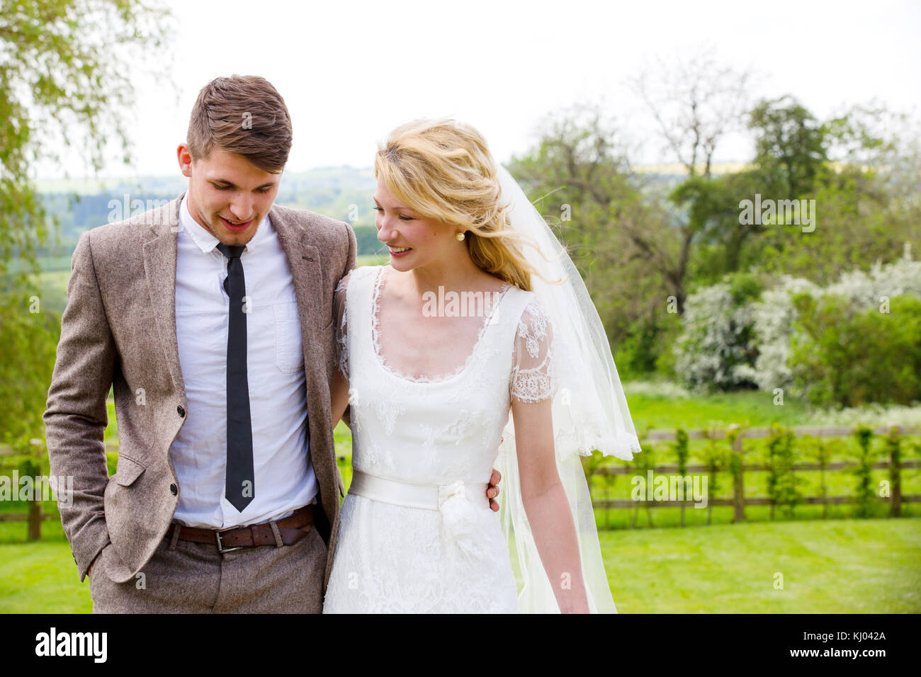 Newlywed couple strolling together in gardens Stock Photo