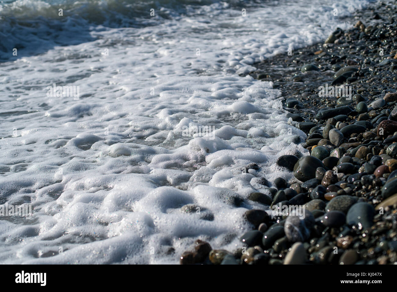 Stones on beach and sea water Stock Photo - Alamy