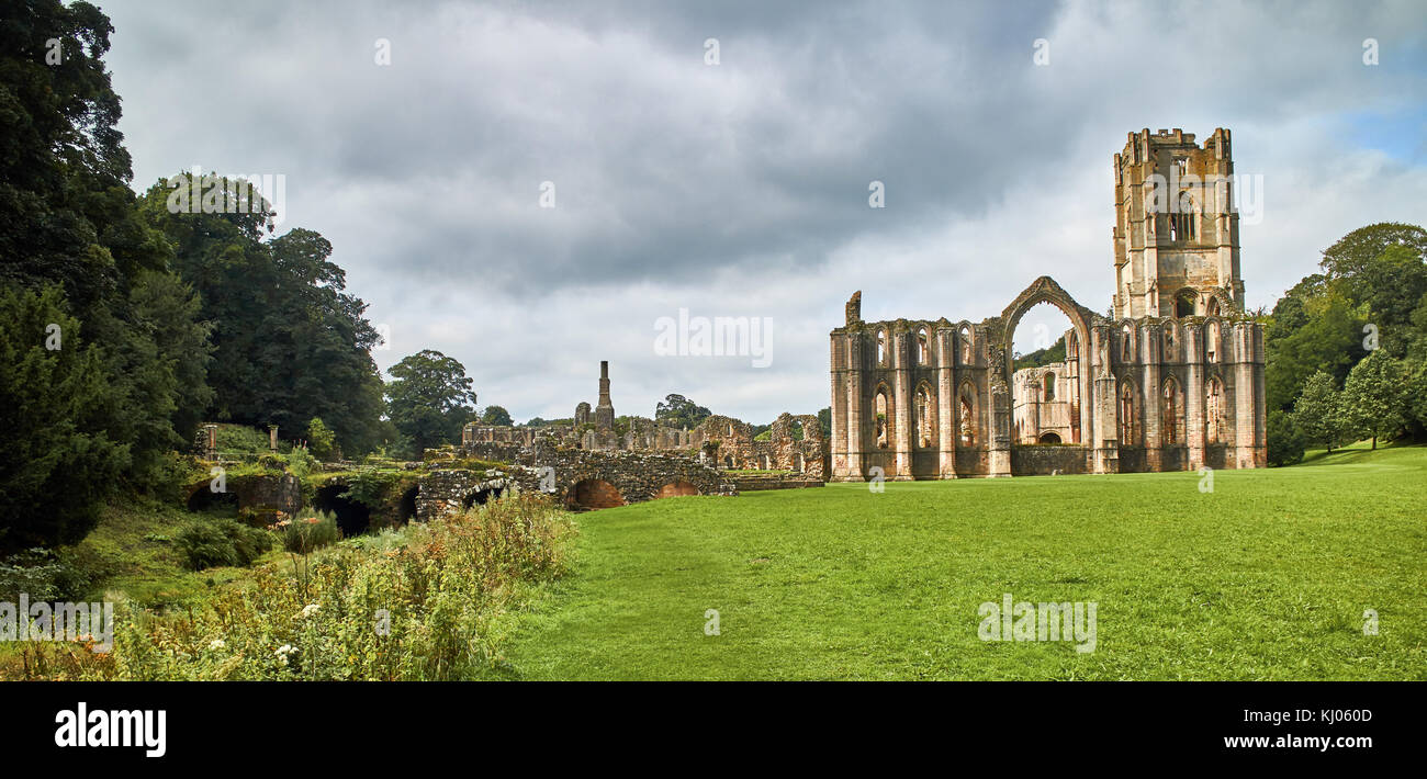 England, NorthYorkshire; the ruins of the 12th century Cistercian Abbey known as Fountains Abbey, one of the finest examples of monastic architecture in the world. The tower by Abbot Huby, (1495-1526), still dominates the valley landscape. Together with its surrounding 800 acres of 18th century landscaped parkland, Fountains Abbey has been designated a UNESCO World Heritage Site. North Yorkshire, England, UK. Ca. 1995. | Location: near Ripon, Yorkshire, England, UK. Stock Photo