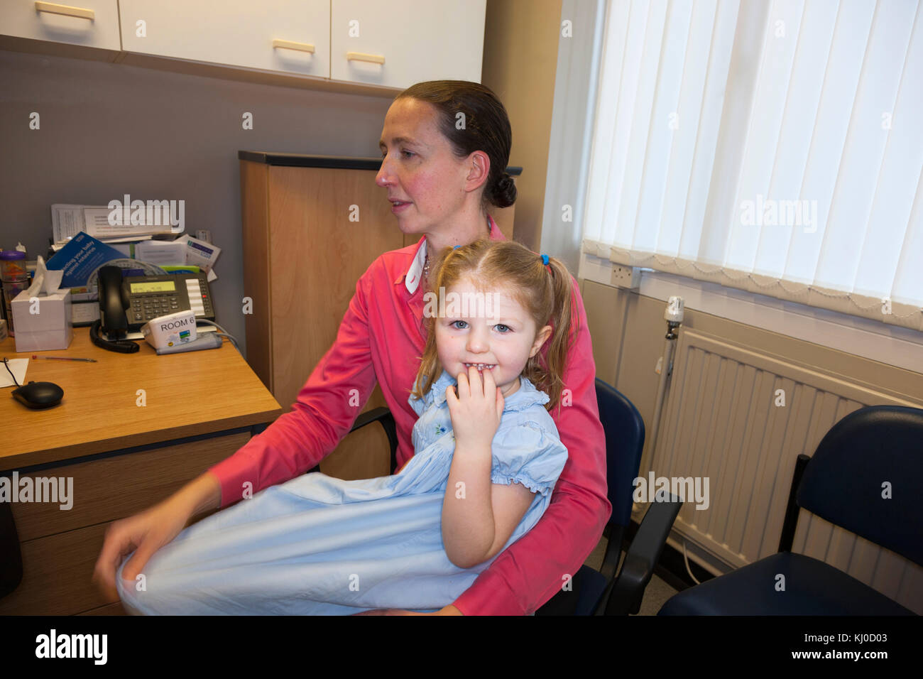 NHS Practice nurse giving a kids sticker to a 3 three year old child ...