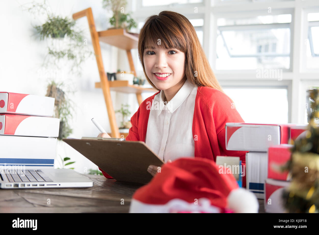 start up small business owner working with computer at workplace. freelance woman seller check product order to prepare for delivery to customer.  Onl Stock Photo