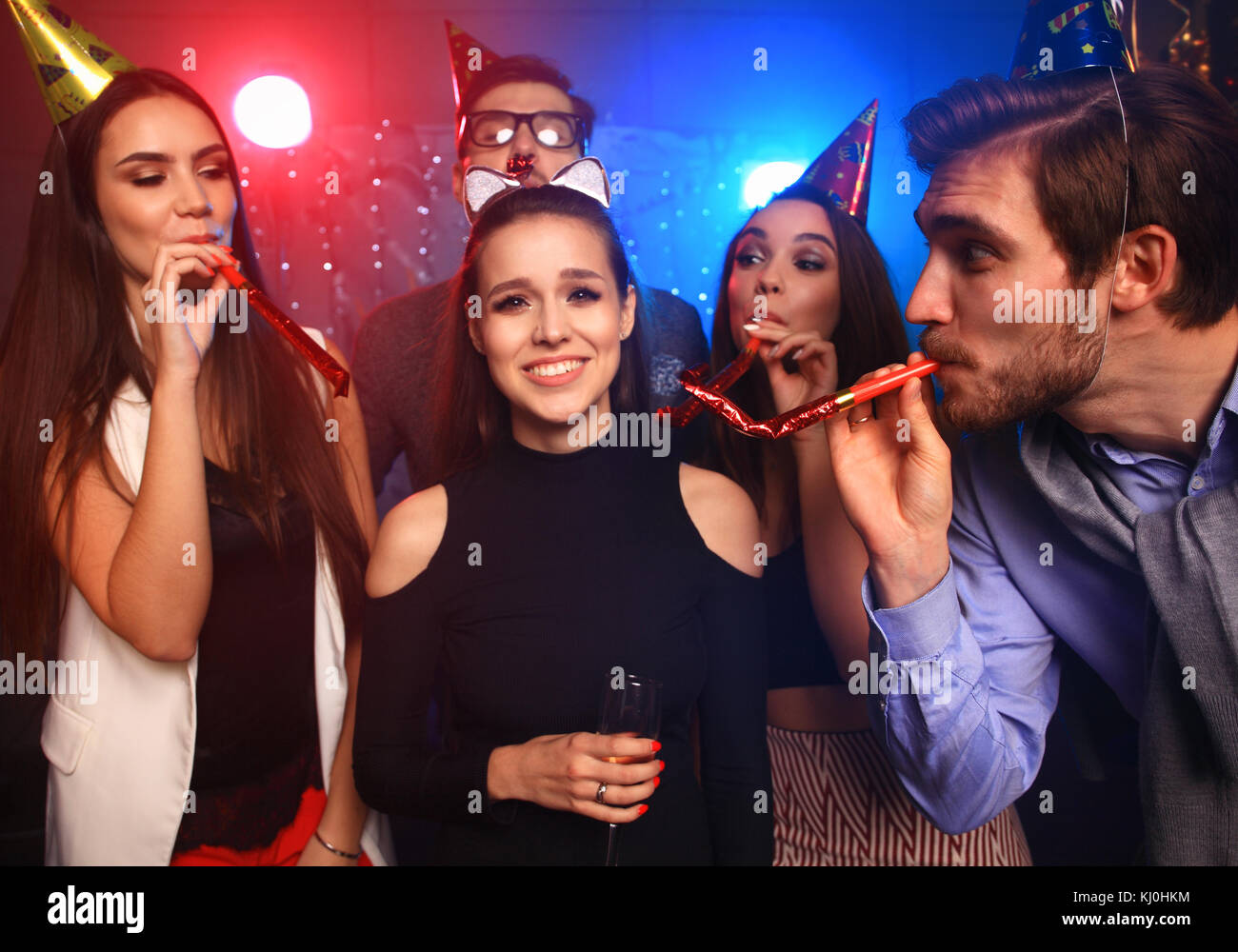 Friends making big party in the night. Five people throwing confetti