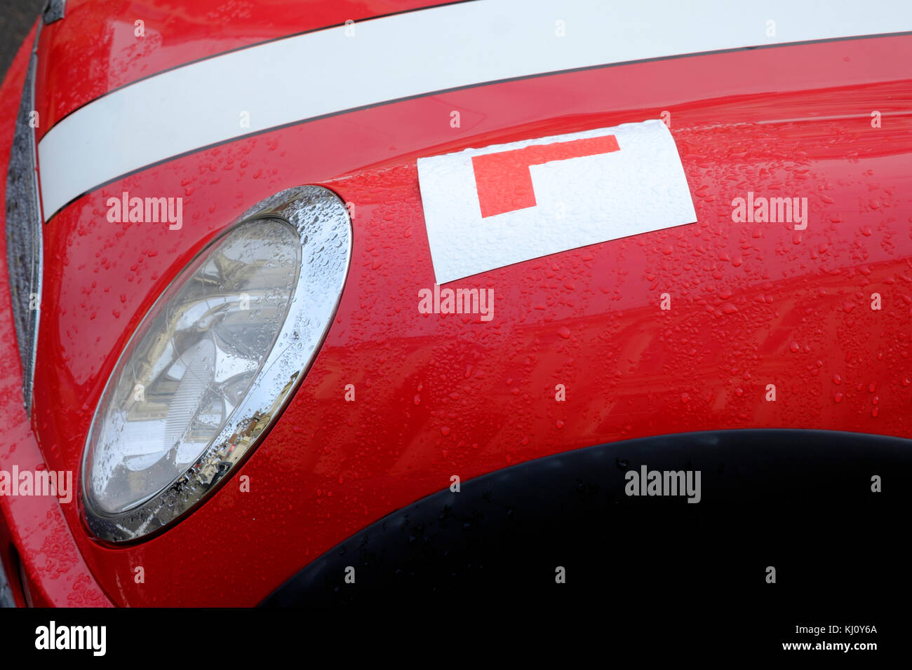 red and white mini car with a learner plate on the front wing england uk Stock Photo
