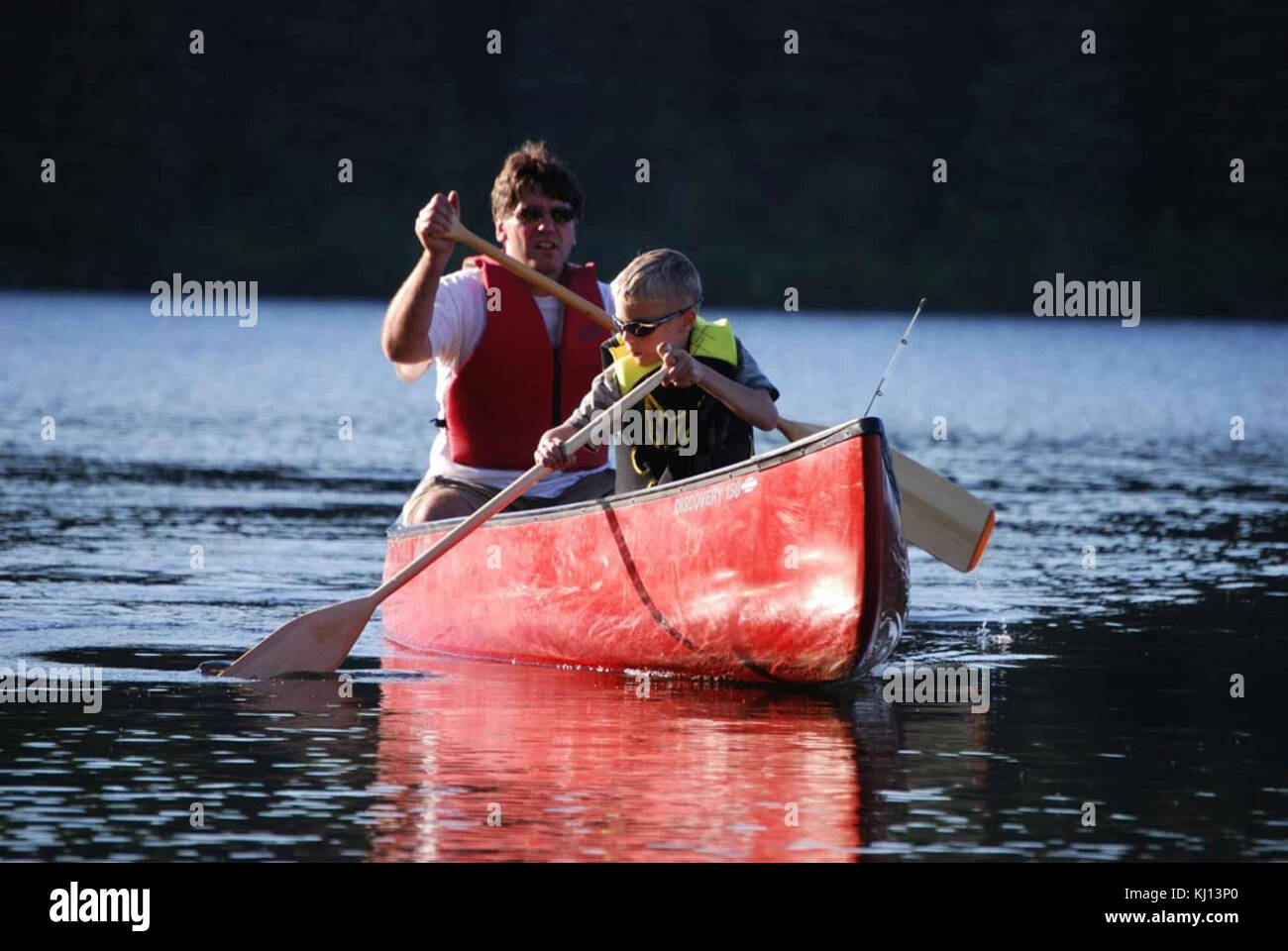 Man and boy paddle a canoe Stock Photo - Alamy