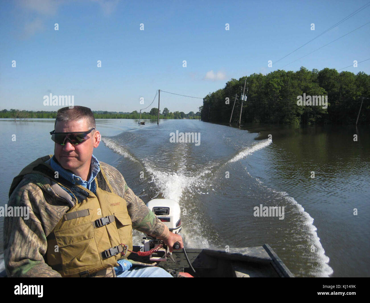 Man driving small boat Stock Photo - Alamy