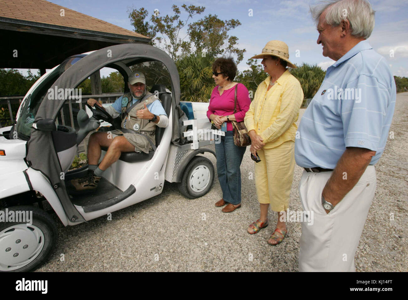 Man gives a thumbs up to visitors showing his total enjoyment with this new electric car Stock Photo