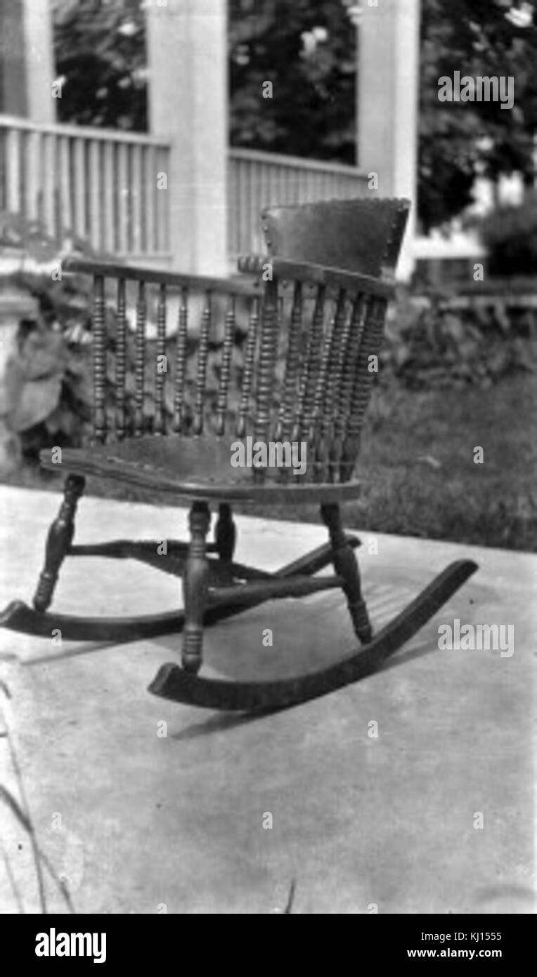 This wooden rocking chair, a classic piece of furniture, features a curved design to allow gentle rocking motion. It is a popular item for relaxation and was widely used in homes and porches during the 19th and early 20th centuries. Stock Photo