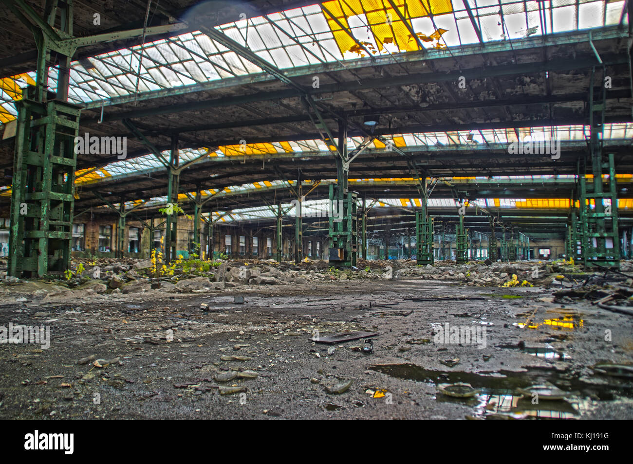 Abandoned old factory hall with windows in roof. Large space in forgotten industrial interior. Stock Photo