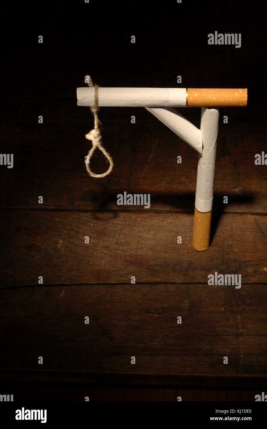 Gibbet made from cigarettes and rope on dark wooden background Stock Photo