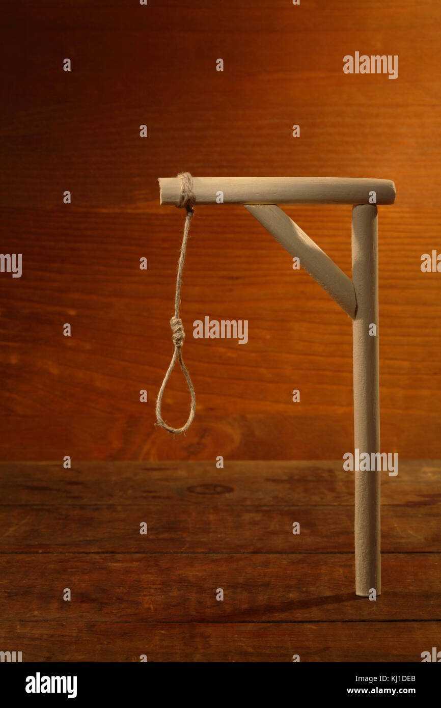 Gibbet with loop on gloomy wooden background Stock Photo