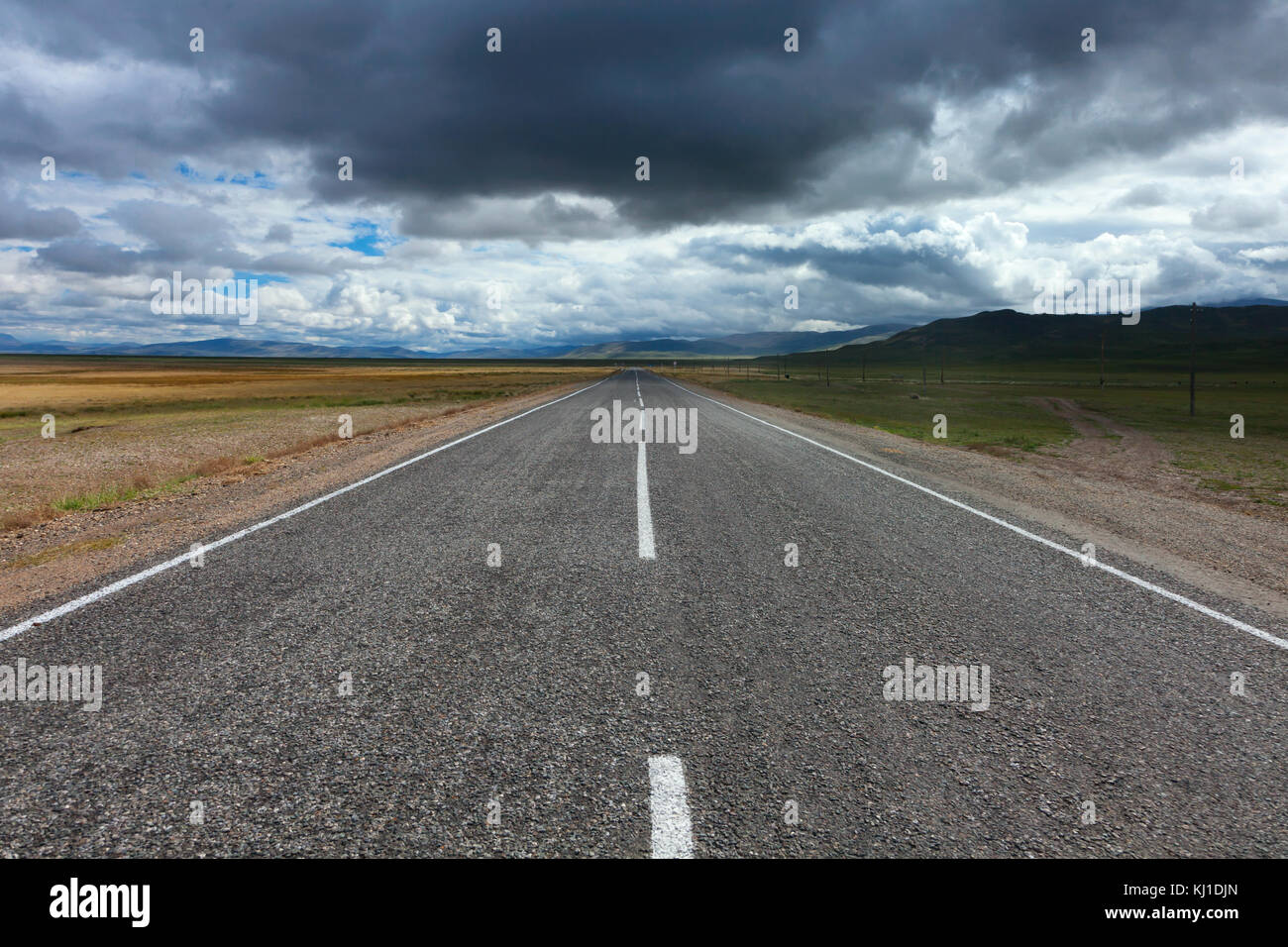 An empty desert road with dark and foreboding storm clouds on the ...