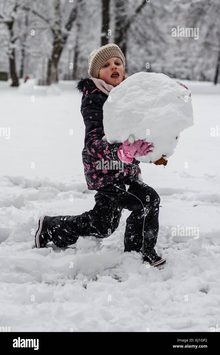 child playing in winter park with snow ball Stock Photo - Alamy