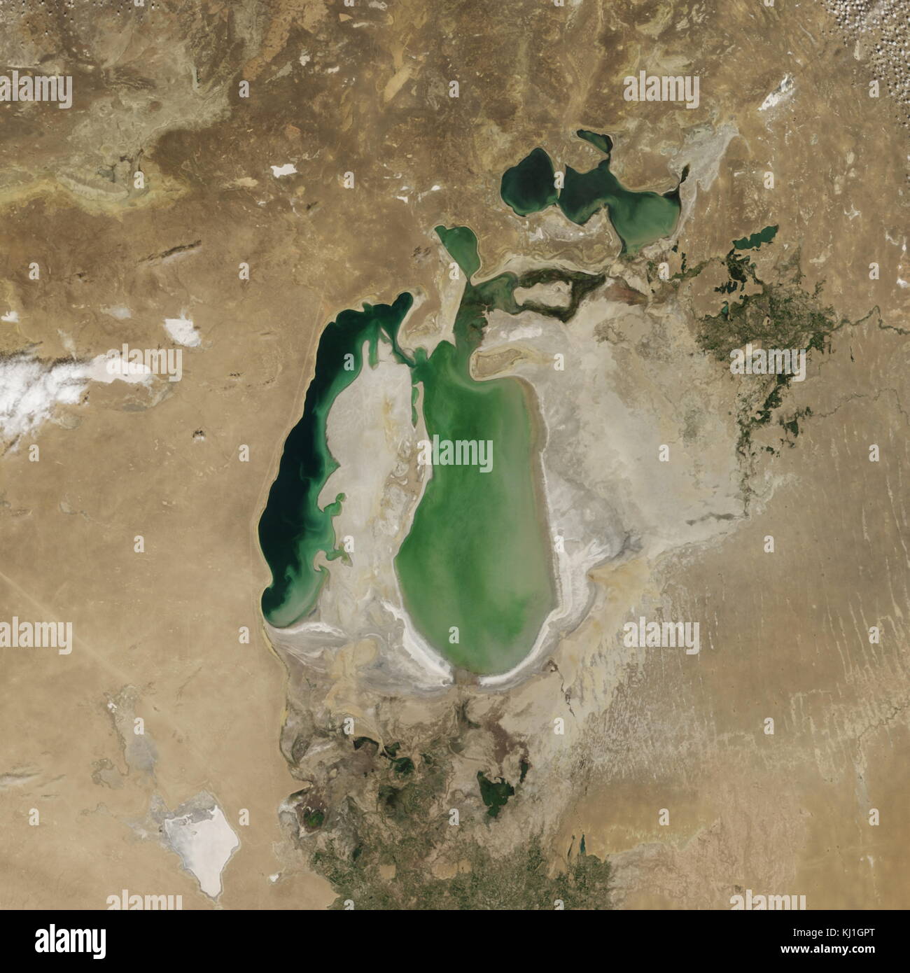 Satellite image of the shrinking of the Aral Sea taken in 2002. The Aral Sea, is a lake lying between Kazakhstan, in the north and Uzbekistan in the south. The name roughly translates as 'Sea of Islands', referring to over 1,100 islands that once dotted its waters; Formerly one of the four largest lakes in the world with an area of 68,000 km2 (26,300 sq mi), the Aral Sea has been steadily shrinking since the 1960s after the rivers that fed it were diverted by Soviet irrigation projects. Stock Photo