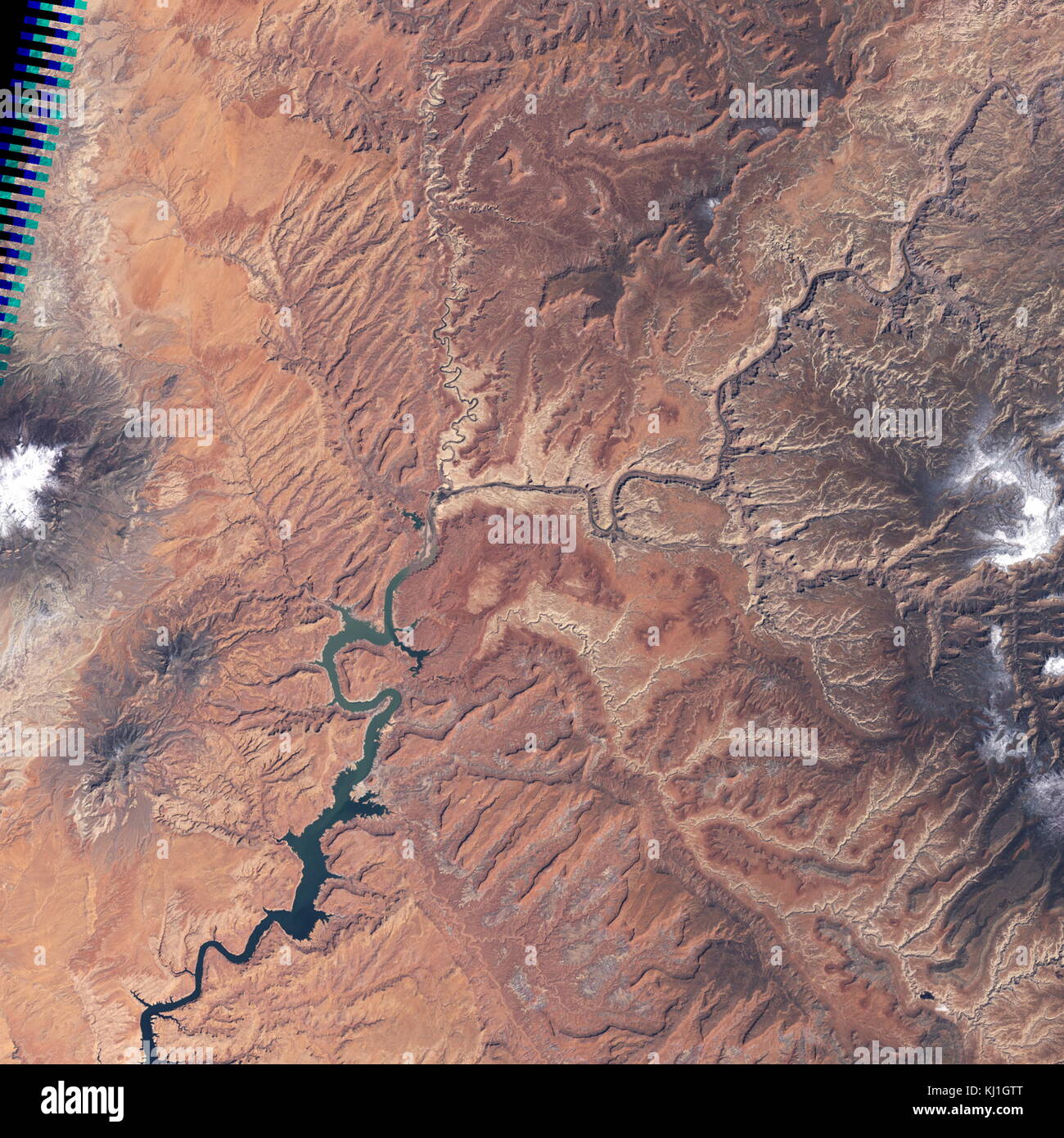 Lake Powell, is a reservoir on the Colorado River, straddling the border between Utah and Arizona (most of it, along with Rainbow Bridge, is in Utah). It is the second largest man-made reservoir by maximum water capacity in the United States behind Lake Mead. Satellite image, taken in 2004 Stock Photo