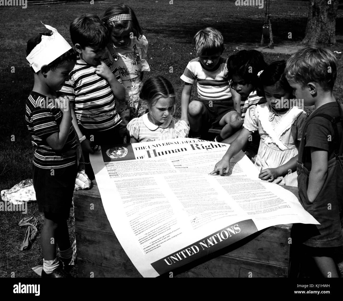 Photograph taken of children of the United Nations International Nursery School looking at a poster of the Universal Declaration of Human Rights. Dated 20th Century Stock Photo