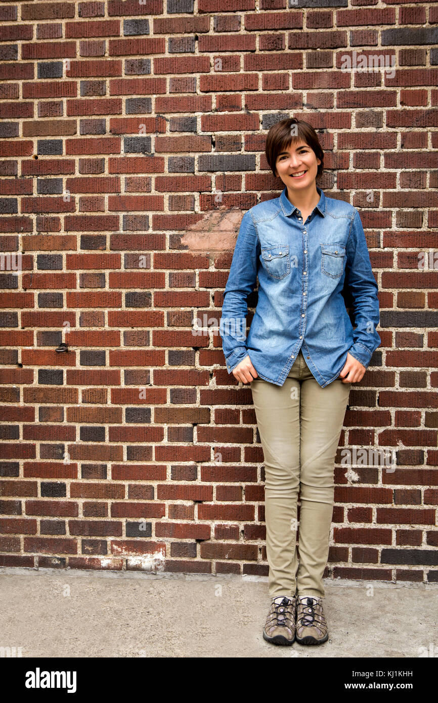Outdoor portrait of a woman in front of a brick wall Stock Photo - Alamy