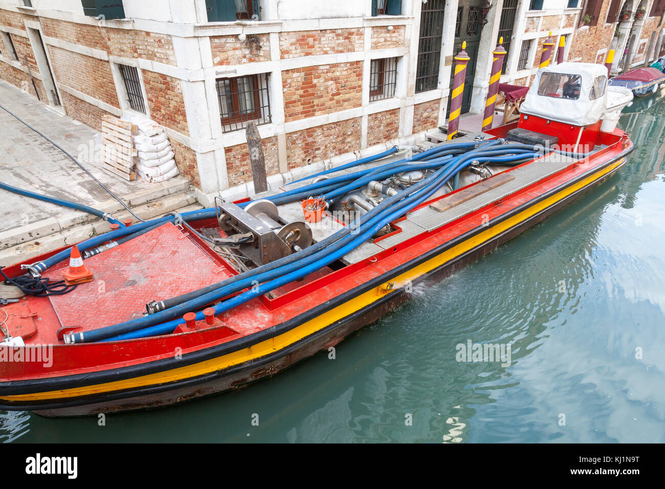 Boat  pumping out a domestic biological septic tank during servicing and maintenance  of effluent and sewage in Venice, Italy Stock Photo