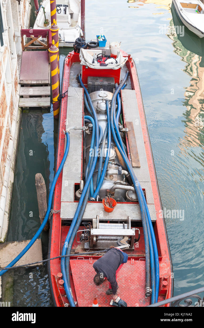 Boat servicing a domestic biological septic tank in Venice, Italy for the purification and disposal of sewage and effluent Stock Photo