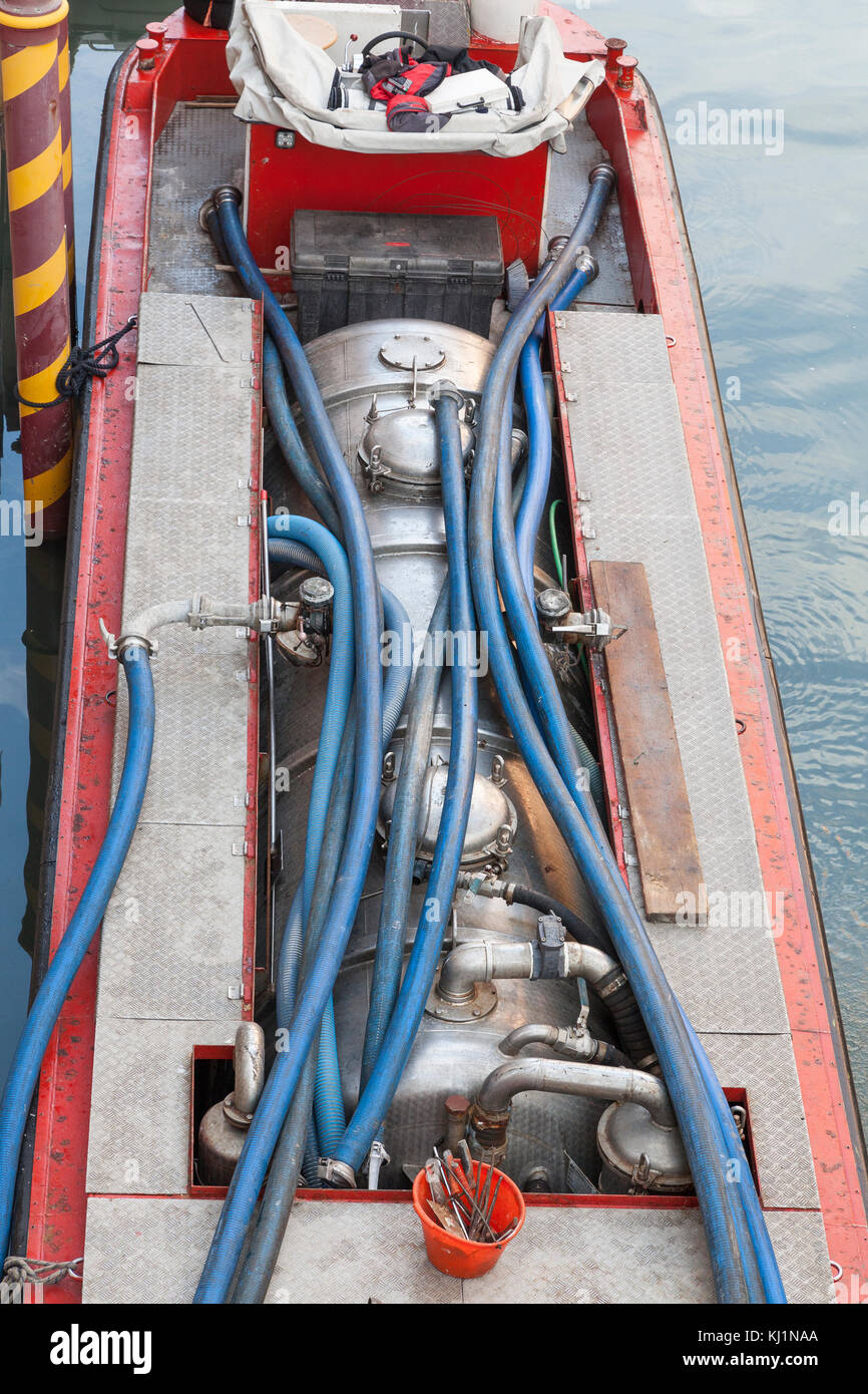 Specialised boat performing maintenance on a domestic biological tank, Venice, Italy during purification and disposal of sewerage Stock Photo