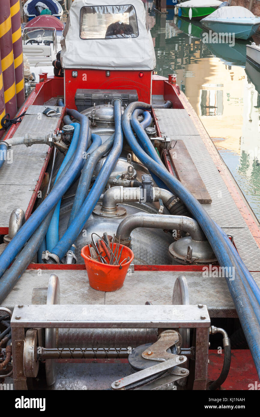 Servicing a domestic biological septic tank for sewage purification in Venice, Italy with a specialised sanitation boat equipped with a pump Stock Photo