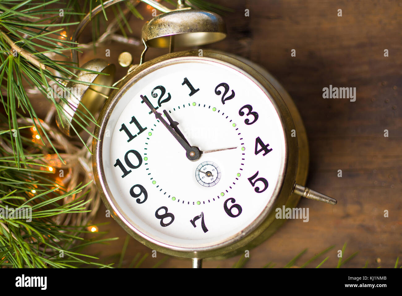 Vintage clock approaching midnight and festive Christmas lights Stock Photo