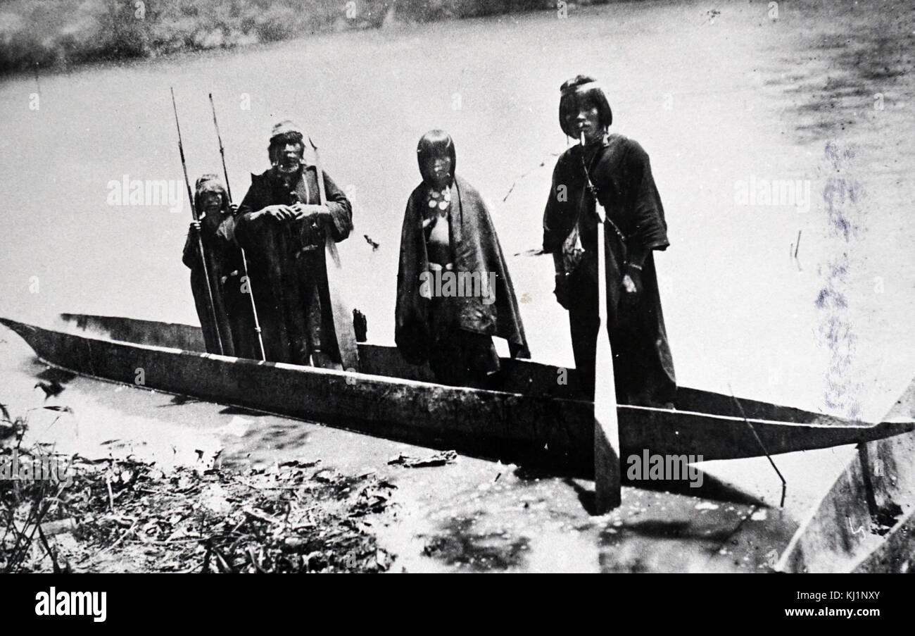 Photograph of Amazonian Indians in a dugout canoe. Dated 19th Century Stock Photo