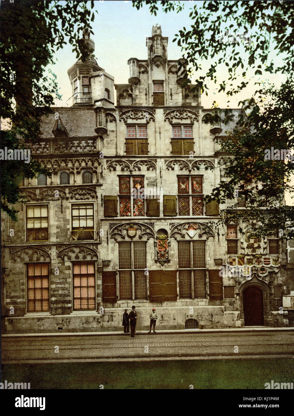 photomechanical print dated to 1900, depicting Gemeenlandshuis, Delft, was built circa 1505, as the house of the very wealthy Jan de Huyter. The front façade is decorated with numerous little monsters and hop bells. The tower has a beautifully gilded weathervane which depicts a mermaid. Stock Photo