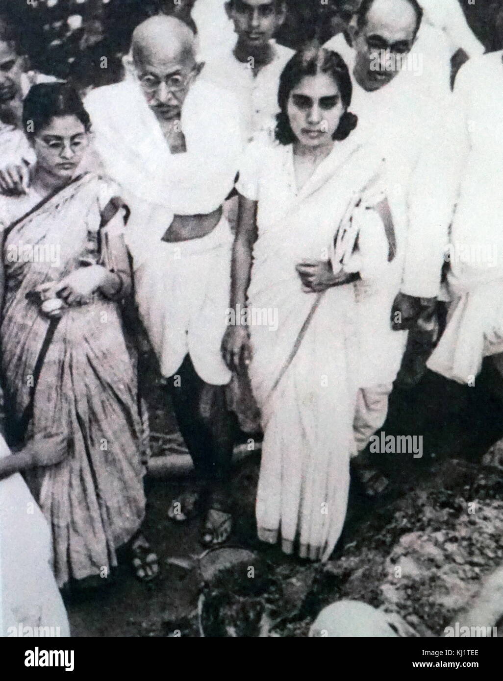 Mahatma Gandhi after a hunger strike is supported by his granddaughter Abha (left) and his doctor Sushila Nayyar. Pyarelal Nayyar his personal secretary stands to the far right. Stock Photo