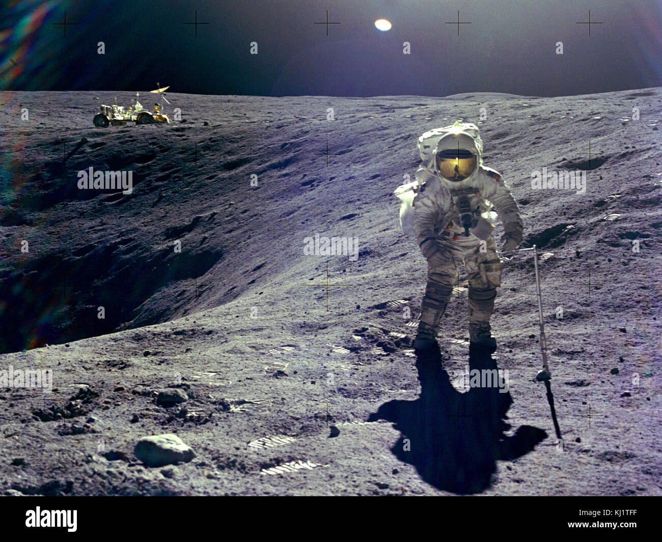 Astronaut Charles M. Duke, Jr., lunar module pilot of the Apollo 16 lunar landing mission, is photographed collecting lunar samples at Station no. 1 during the first Apollo 16 extravehicular activity at the Descartes landing site. This picture, looking eastward, was taken by Astronaut John W. Young, commander. Duke is standing at the rim of Plum crater, which is 40 meters in diameter and 10 meters deep. The parked Lunar Roving Vehicle can be seen in the left background. Stock Photo