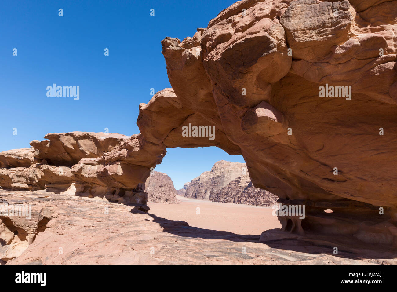natural rock bridge and panoramic view of Wadi Rum desert, Jordan Stock Photo