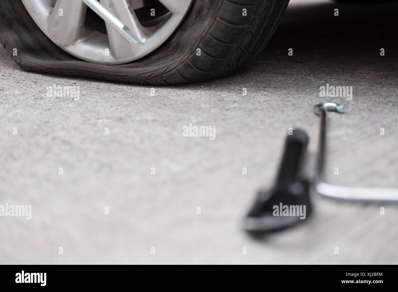Car tire leak because of nail pounding. flat tyre on road. Flatten