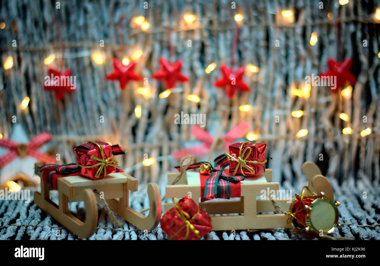 Christmas decoration,holidays and decor concept-close up christmas sledge with gifts on golden lights background. Stock Photo