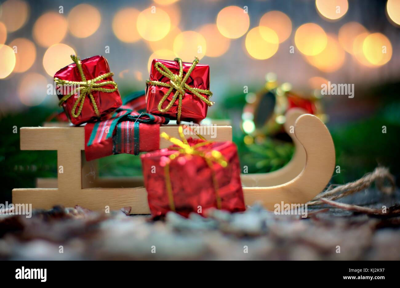 Christmas decoration,holidays and decor concept-close up christmas sledge with gifts on golden lights background. Stock Photo