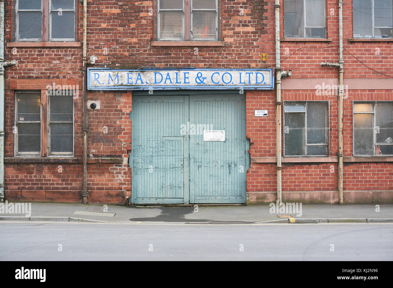 Glasgow, UK - 6 November 2017 : An old gate and a company sign on a historic red brick building. Stock Photo