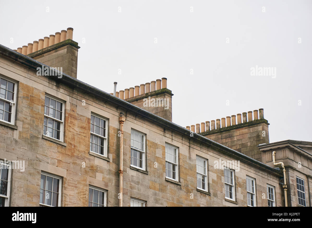Rows of chimneys on typical sandstone tenement buildings in UK Stock Photo