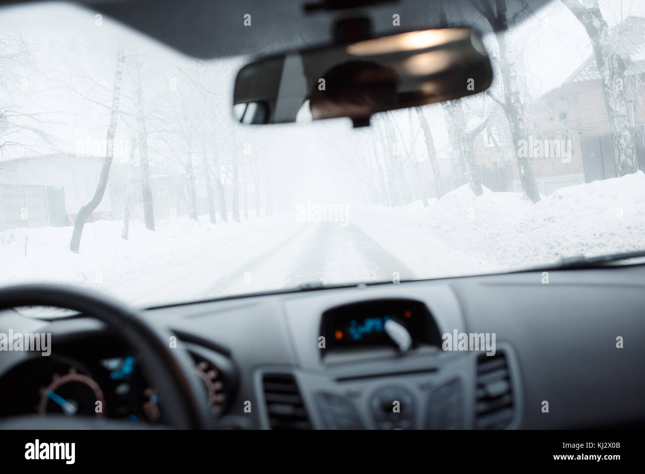 Bad weather driving in winter. Blizzard and fog on the road with low