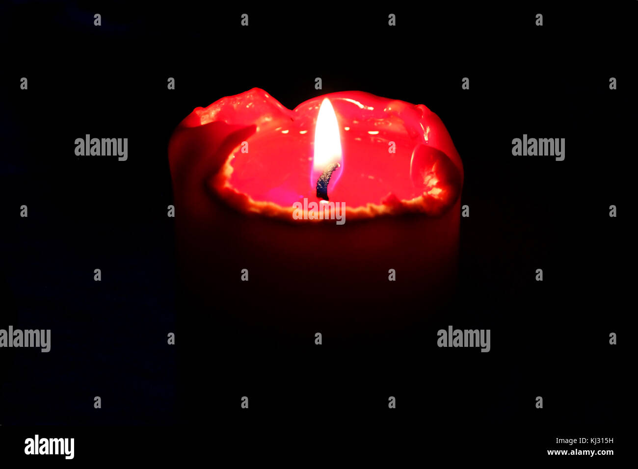 The red candle burns in the dark during the ritual. Stock Photo