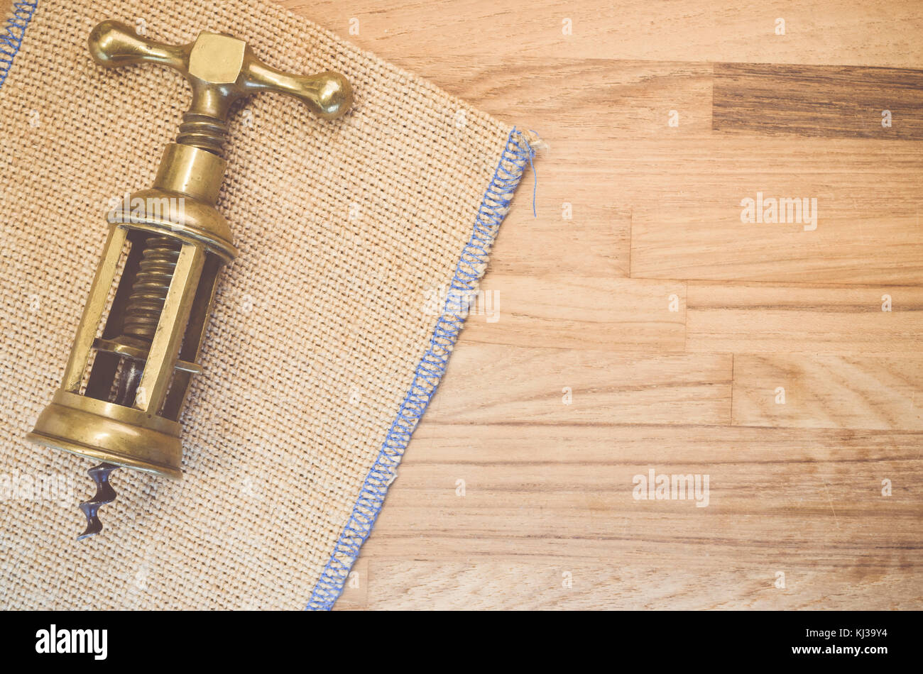 vintage hand made solid brass corkscrew on a natural wood and burlap  background Stock Photo - Alamy