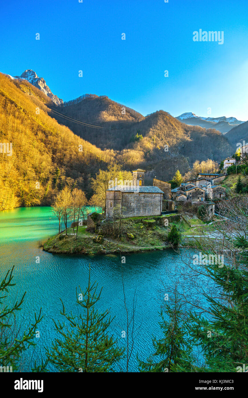 Isola Santa medieval village, church, lake and Alpi Apuane mountains. Garfagnana, Tuscany, Italy Europe Stock Photo