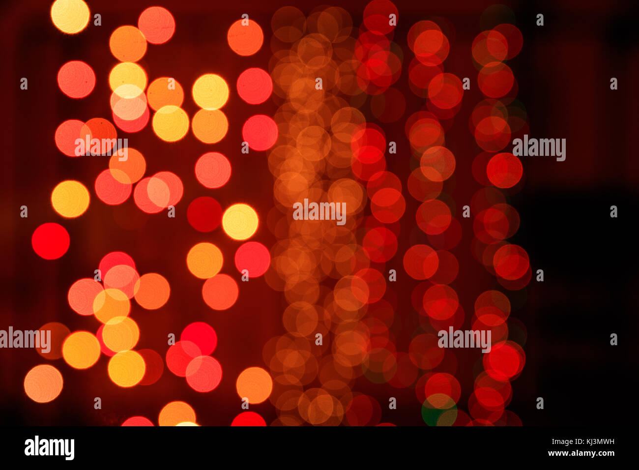 Christmas lights bokeh background. Orange, yellow and red lights on dark background Stock Photo