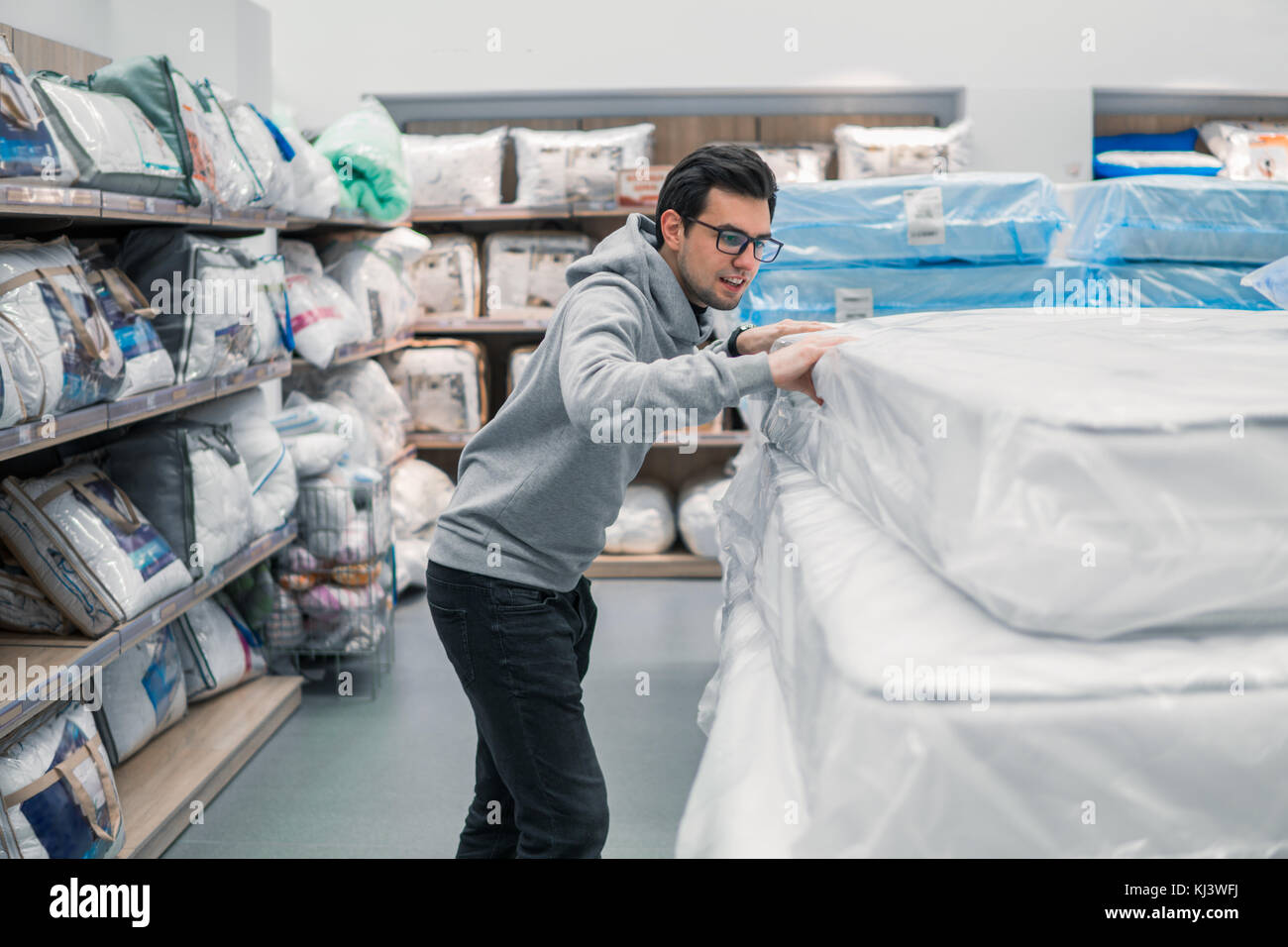 Customer man chooses bed linen in the supermarket mall store. Stock Photo