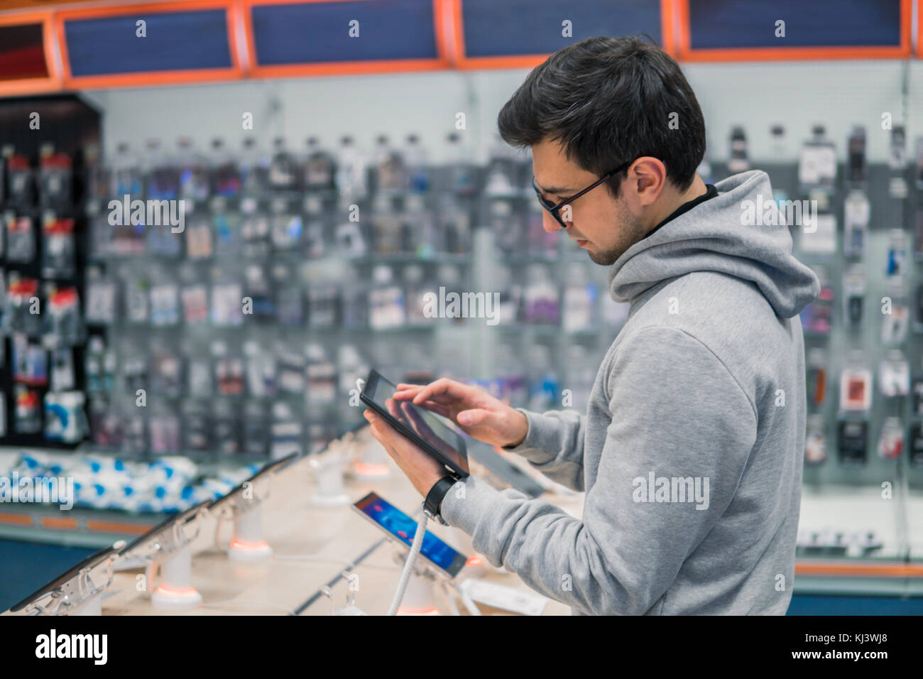 Customers Using Tablets smart male customer choosing digital tablet Stock Photo - Alamy
