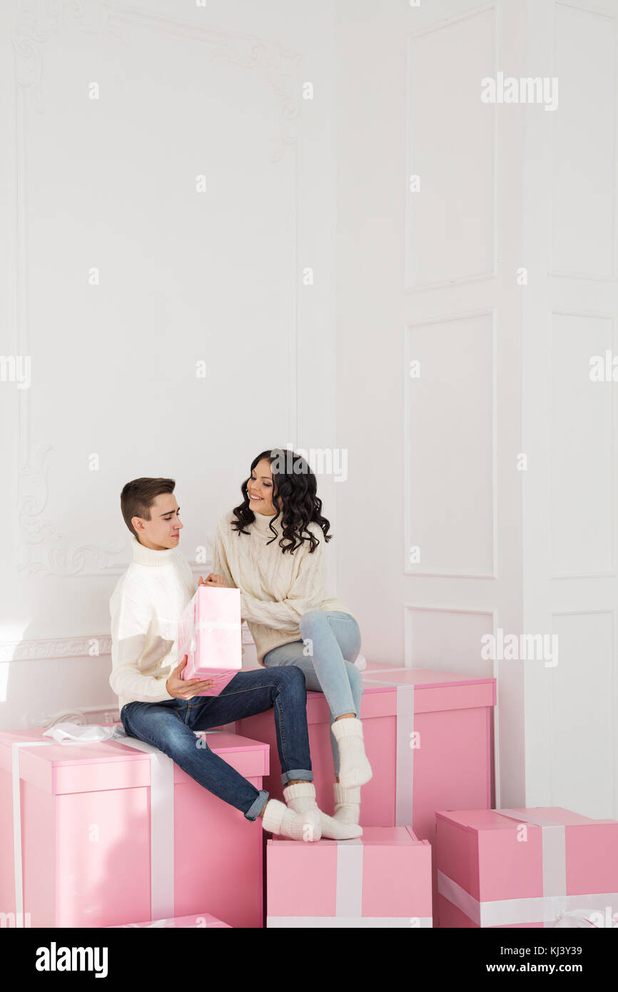 A Loving Couple Of Teenagers Are Sitting On Presents She